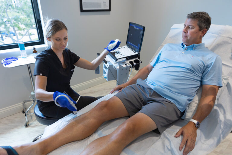 A mature man liying on a treatment bed as a provider prepares to delver DVT treatment in Sarasota