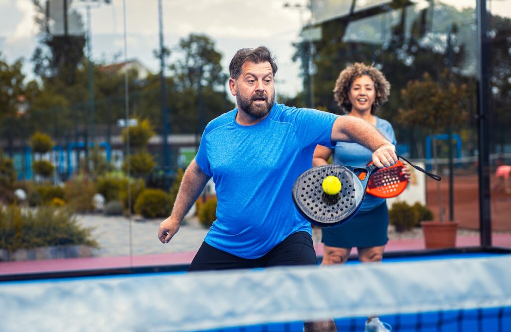 A husband and wife playing pickleball on an outdoor court after successfully undergoing Varithena near Bradenton, FL.