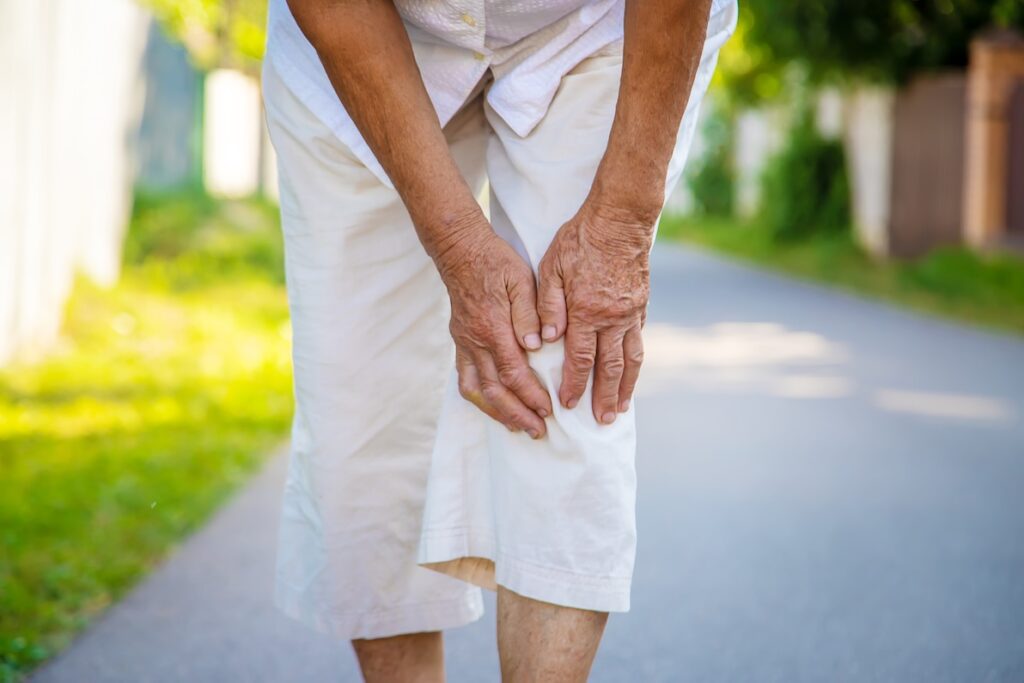 An older woman holds her knee in pain, wondering if it is time to look for DVT treatment in Lakewood Ranch.